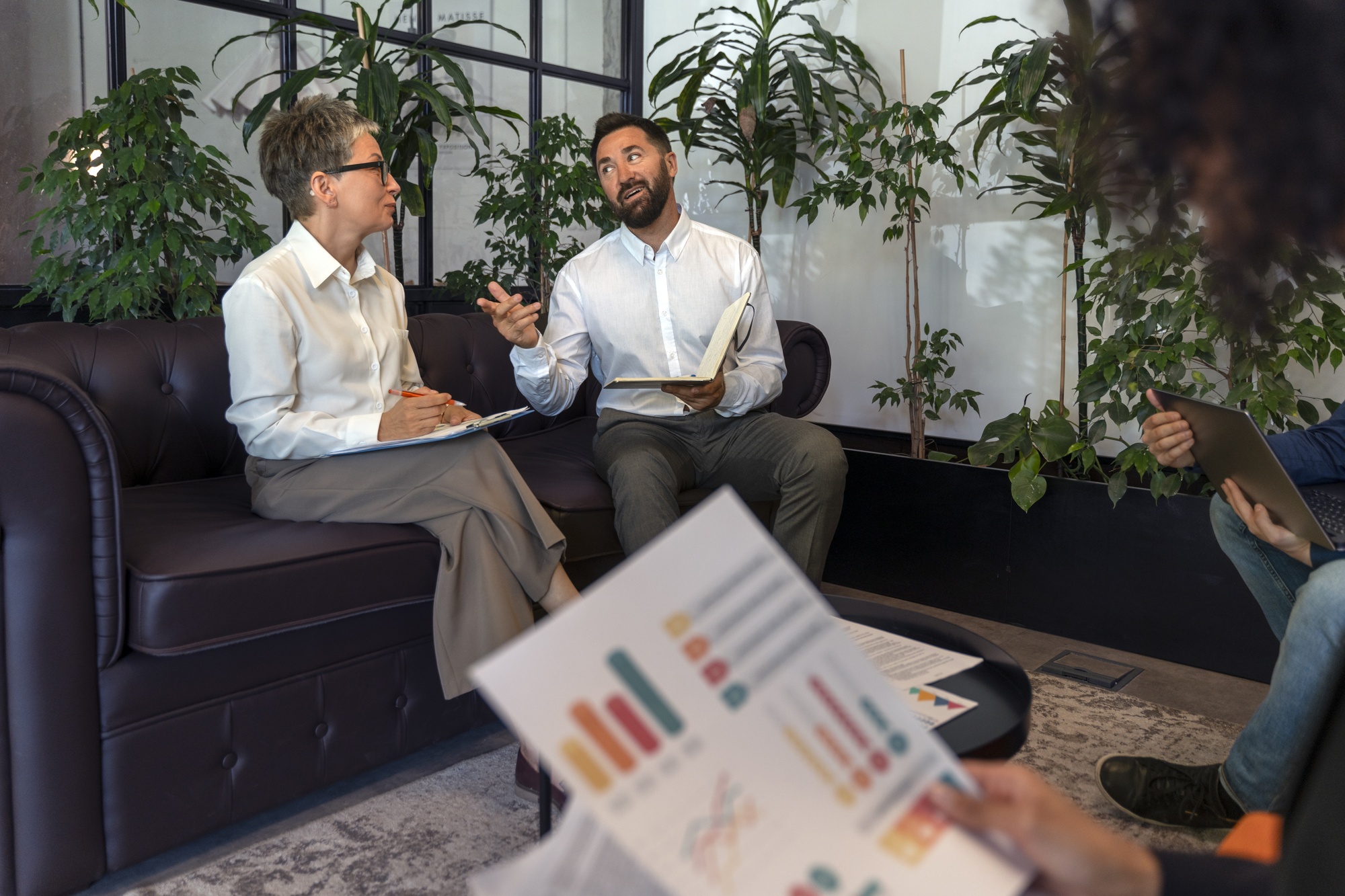 Berater diskutiert Finanzstrategie mit Klienten in elegantem Büro